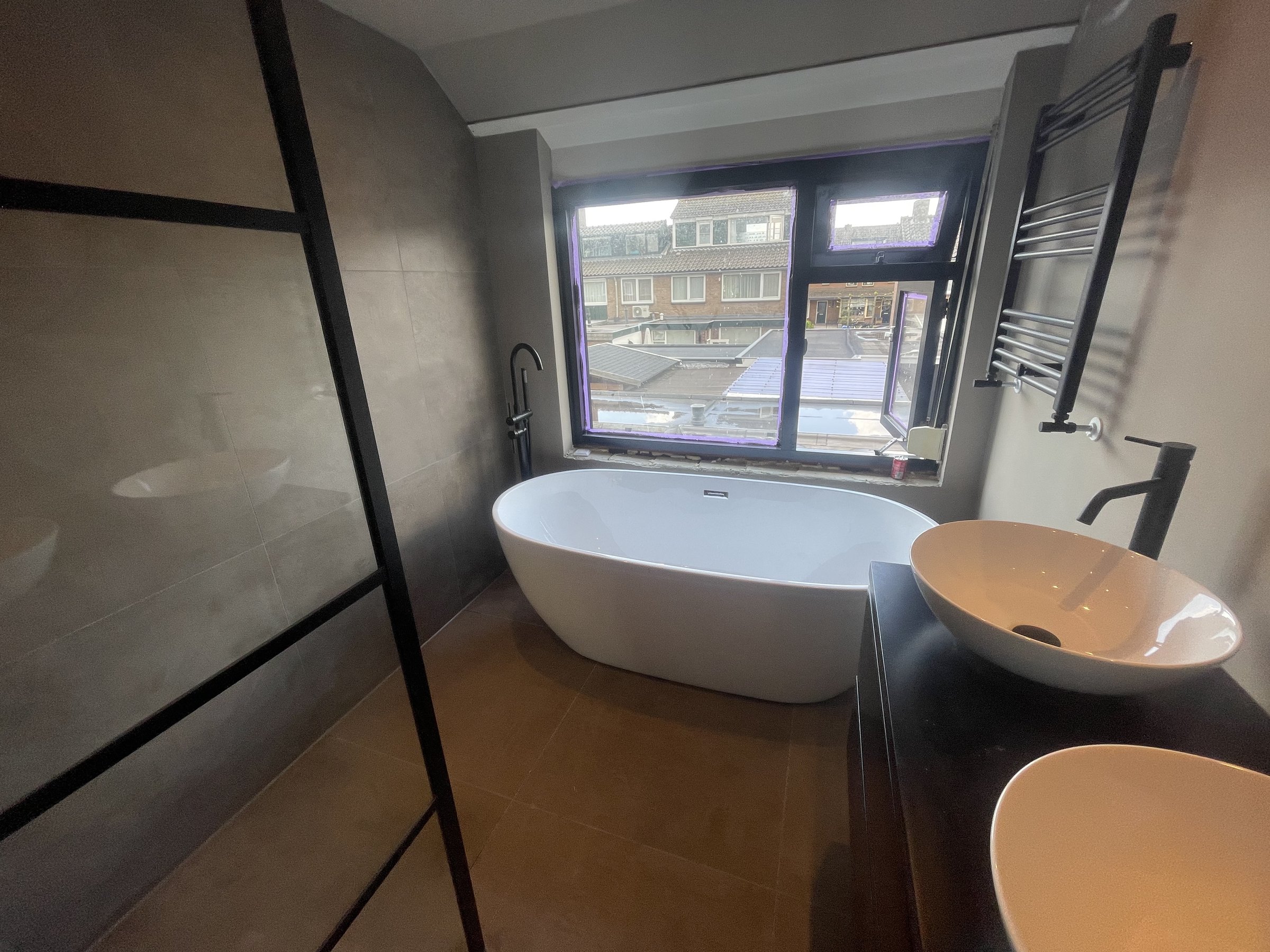 Badkamer in Harderwijk met vrijstaand bad bij het raam, opgeleverd door VJ Installatietechniek